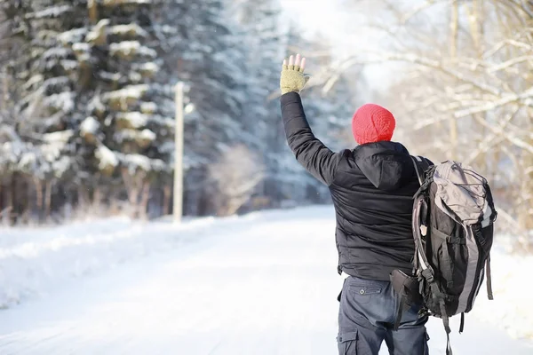 A man travels with a backpack. Winter hike in the forest. Touris — ストック写真