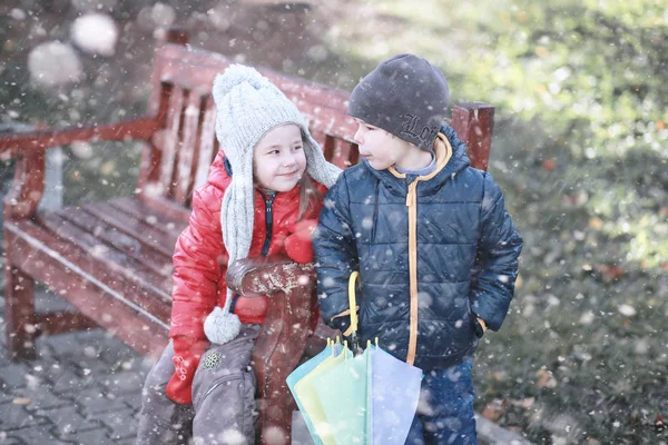 Dzieci chodzą w parku pierwszy śnieg — Zdjęcie stockowe