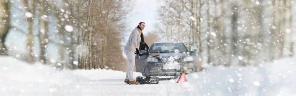Egy ember egy törött autó, egy téli napon közelében — Stock Fotó