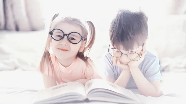 Les enfants s'allongent sur le lit à côté du nouveau-né, petite sœur . — Photo