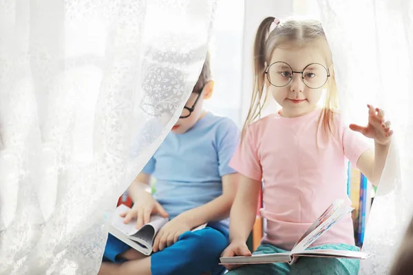 Kinderen liggen op het bed naast de pasgeboren baby, zusje. — Stockfoto