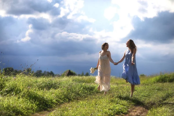 Young girls are walking in the field — Stock Photo, Image