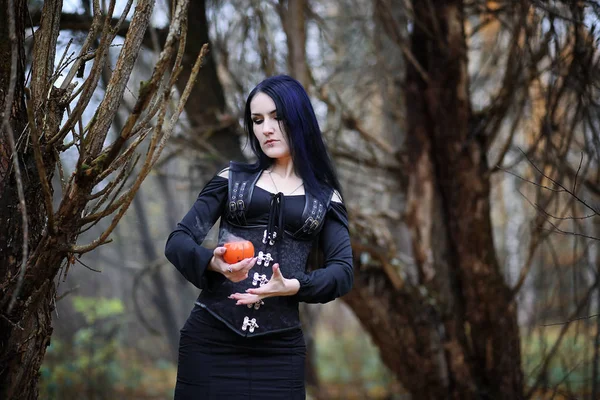 A woman in a witch suit in a forest — Stock Photo, Image