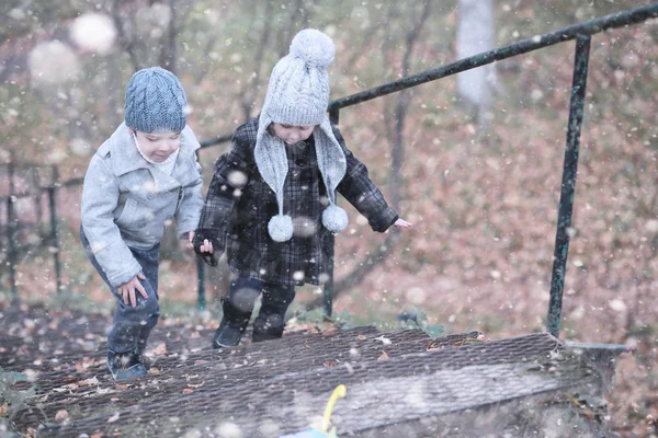 I bambini camminano nel parco prima neve — Foto Stock