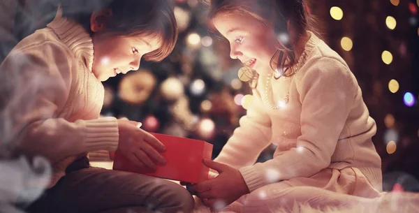 Familia en la víspera de Navidad en la chimenea. Niños abriendo regalos de Navidad —  Fotos de Stock