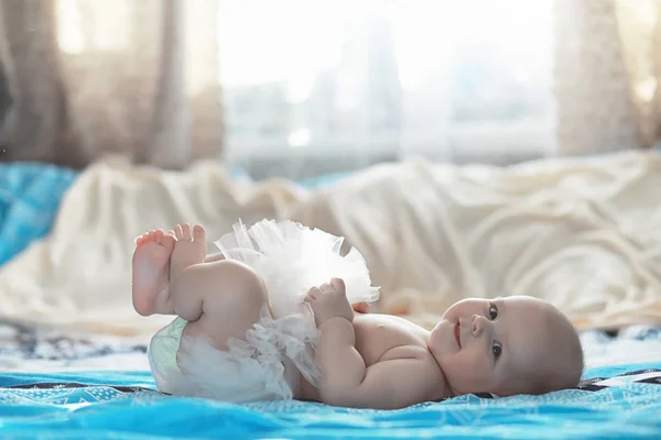 Ett nyfött barn ligger på en mjuk säng. — Stockfoto