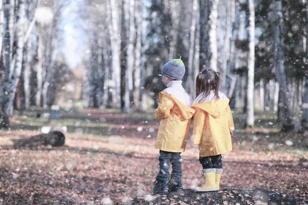 子供たちは公園の最初の雪の中を歩く — ストック写真