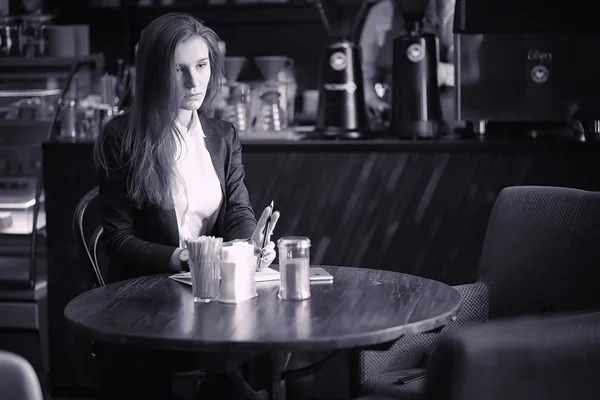 En flicka i ett café dricker kaffe. En kvinna har frukost — Stockfoto