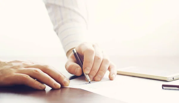 Reunión de negocios. Un hombre firma un contrato. Mano masculina con pluma mak — Foto de Stock