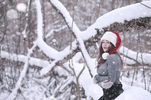 Девушка в зимнем парке при снегопаде — стоковое фото