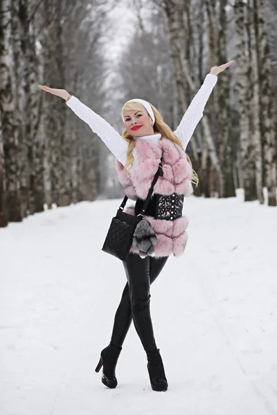 Menina loira em um passeio em um parque de inverno — Fotografia de Stock