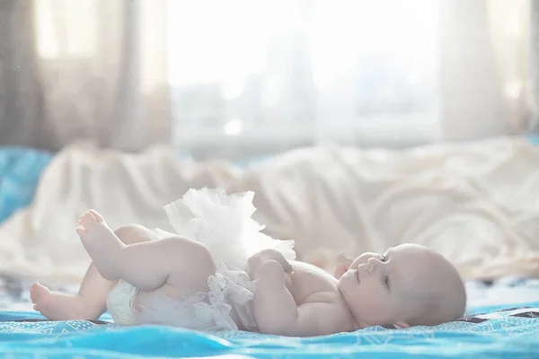 Um bebê recém-nascido está deitado em uma cama macia . — Fotografia de Stock