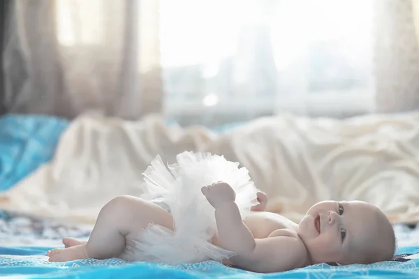 Een pasgeboren baby ligt op een zacht bed. — Stockfoto