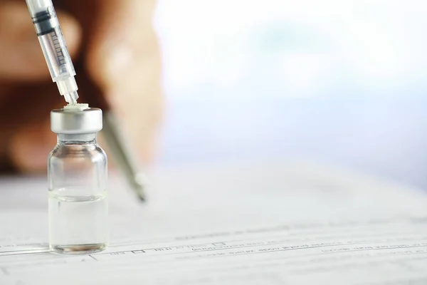 Un hombre firma un documento médico. Equipo médico sobre la mesa . — Foto de Stock