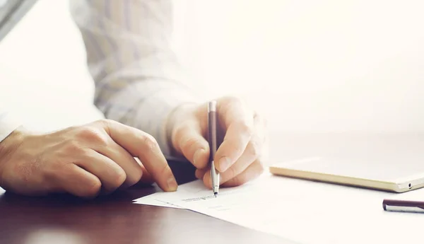 Business meeting. A man signs a contract. Male hand with pen mak Stock Photo
