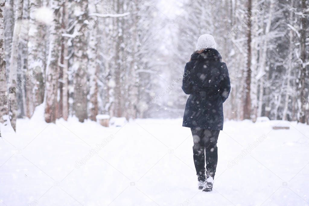 Girl in a winter park in snowfall