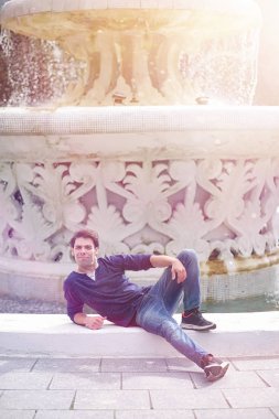 Genç bir adam öğle yemeği zamanında parkta yürür. Bir adam yürüyüşe çıktı. 