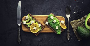 Avokado yemek tarifleri. Olgun yeşil avokado ahşap bir kesim üzerinde 