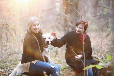 Anne ve genç kız sonbahar bahçesinde yürüyüşe çıktılar.