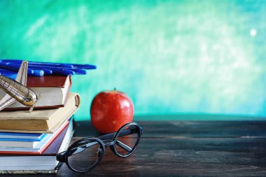 Eğitim konsepti. Bir yığın ders kitabı ve masanın üstünde bir kitap.