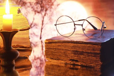 Ay 'ın arka planında eski bir retro kitapta antika gözlükler