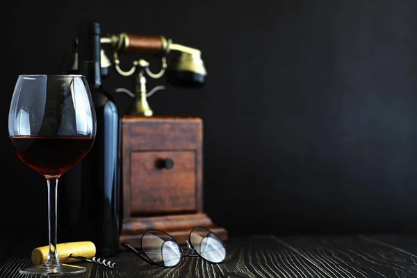 Ein Glas trockenen Rotweins auf dem Tisch. dunkle Flasche und Glas mit Wasser — Stockfoto