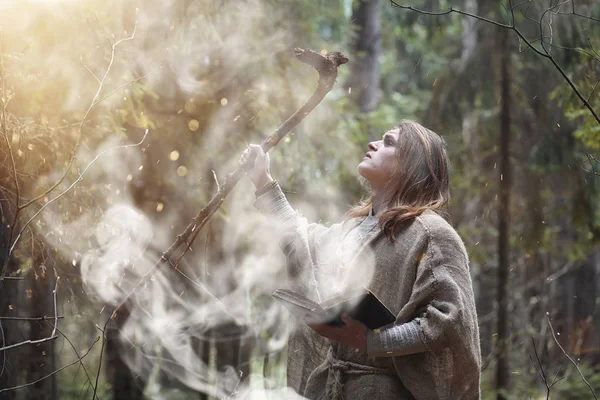 Un uomo con una tonaca trascorre un rituale in una foresta oscura — Foto Stock