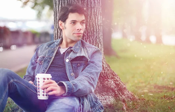 Genç bir adam öğle yemeği zamanında parkta yürür. Bir adam yürüyüşe çıktı. 