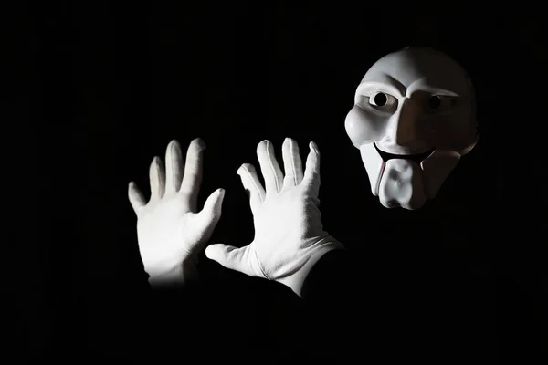 白人の手で黒の背景に白い恐ろしいマスク. — ストック写真