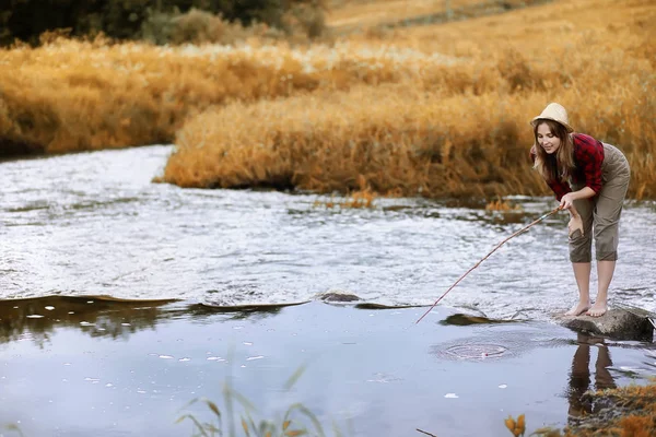 Ragazza in autunno con una canna da pesca — Foto Stock