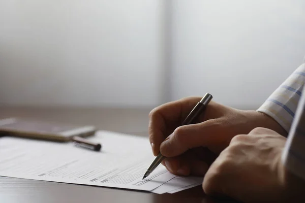 Zakelijke bijeenkomst. Een man tekent een contract. Mannelijke hand met pen mak — Stockfoto