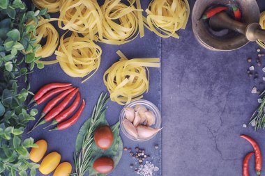 Baharatlı ve sebzeli makarna. Siyah taş üzerinde yemek pişirmek için sebzeli erişte..