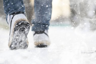 Karlı bir kış gününde bir adam şehirde yürüyor..
