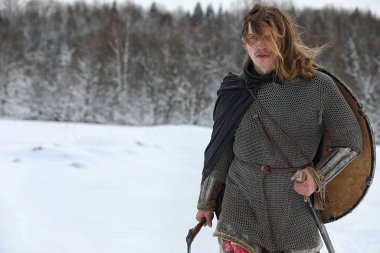 Defender'ı posta zırh genç savaşçı bir kılıç ve balta ile silahlı