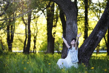 Baharda güneşli bir günün akşamında parkta bir kız.