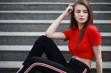 Güneşli bir weathe bir binanın merdivenlerinde poz veren bir kız