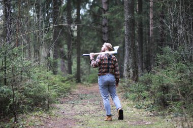 Büyük bir balta ile sakallı bir oduncu ağaç felling önce inceler