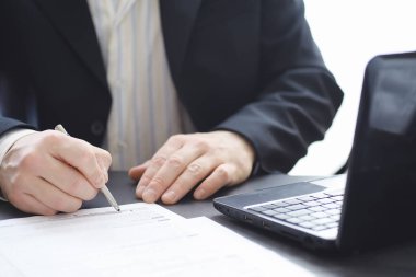 Müdür ofisteki bir dizüstü bilgisayarda çalışıyor. İşadamı çevrimiçi işlem yapıyor. Değiş tokuş internet üzerinden yapılıyor..