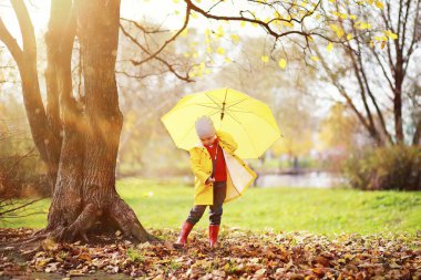 Çocuklar sonbaharda sonbahar parkında yürür