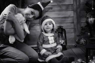 Noel Baba için bekleyen bir Noel ağacı önünde oturan bir çocuk