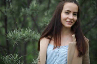 Yağmurlu yağmurda yeşil bir parkta genç bir kız
