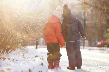 Kışın parktaki çocuklar sno ile oynarlar.