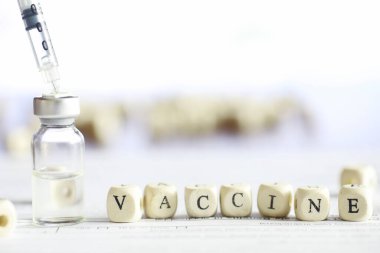 Bir adam tıbbi belge imzalıyor. Tıbbi ekipmanlar masada. Stetoskop ve şırıngalı ampuller. Ofiste notlar alıyor. Tıp Merkezi.