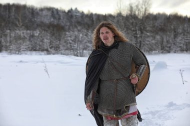 Defender'ı posta zırh genç savaşçı bir kılıç ve balta ile silahlı