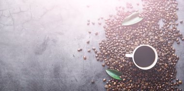 Bir poşet kahve. Kahve çekirdekleri masada kavrulmuş. Pişirmek için yapraklı kahve çekirdekleri.