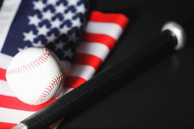 Amerikan geleneksel spor oyunu. Beyzbol mu? Kavram. Amerikan bayrağıyla birlikte beyzbol topu ve sopalar masada..