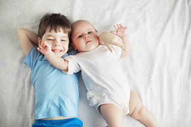 Çocuklar yeni doğan bebeğin yanında yatar, küçük kardeşim. Çocukların duyguları..