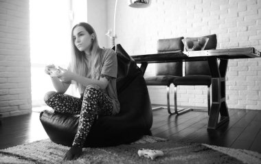 Genç bir kız büyük bir dairede dinleniyor.