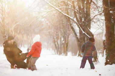 Kışın parktaki çocuklar sno ile oynarlar.