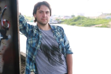 Bir adam sakallı ve kot pantolon endüstriyel bölgede standları